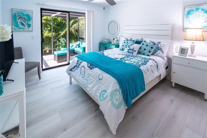Bedroom featuring access to exterior, light wood-style flooring, and ceiling fan