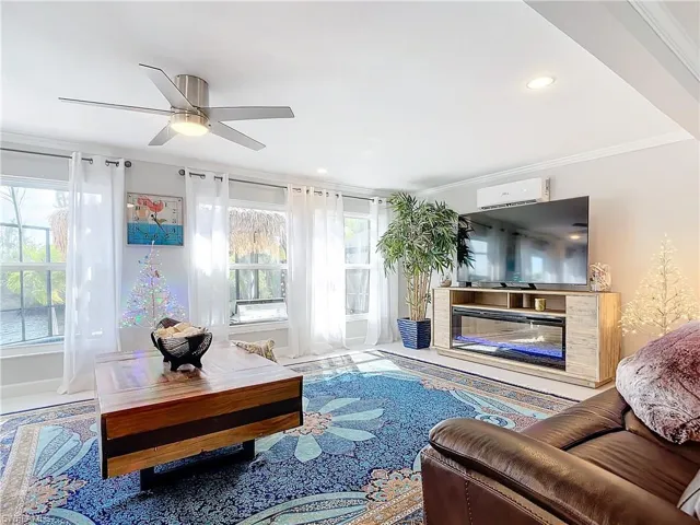 Living room with crown molding, a ceiling fan, and recessed lighting