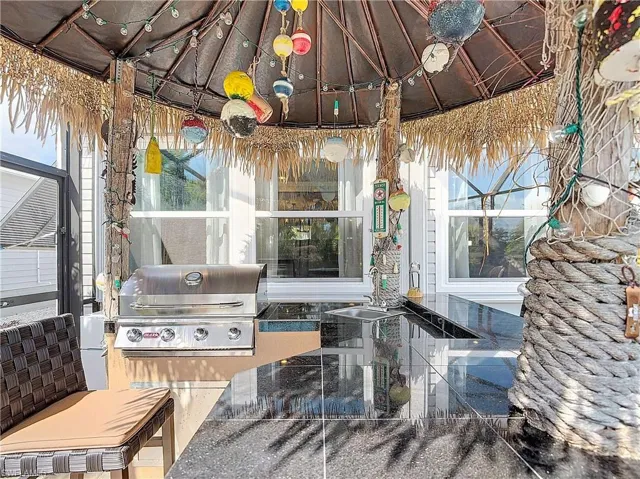 View of patio with grilling area and a gazebo