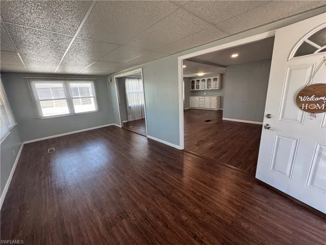 Bonus room, living room , dining room...featuring a drop ceiling and dark wood finished floors