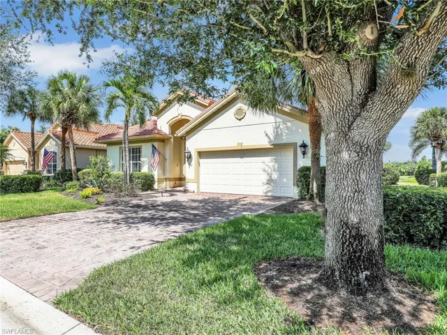 View of front facade featuring stucco siding, a garage, decorative driveway, and a tiled roof