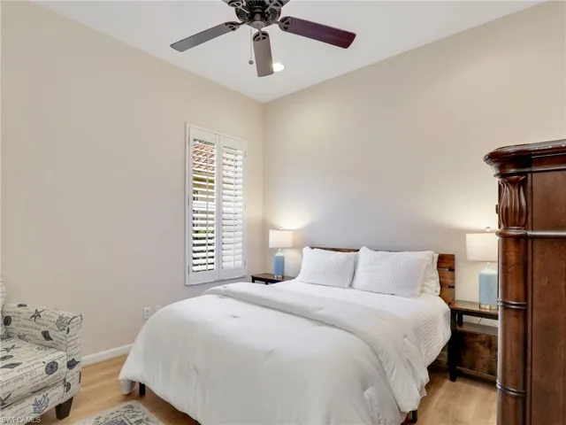 Bedroom featuring light wood finished floors, baseboards, and a ceiling fan