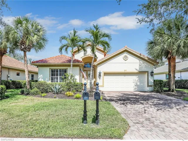 View of front of home with stucco siding, decorative driveway, a garage, a front yard, and a tile roof