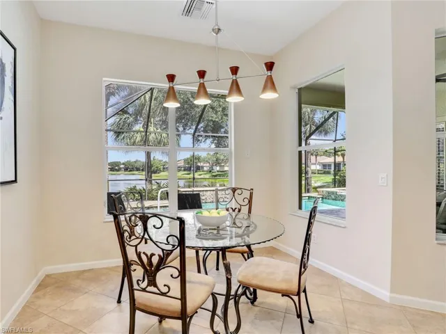 Dining room featuring plenty of natural light, light tile patterned flooring, and a water view
