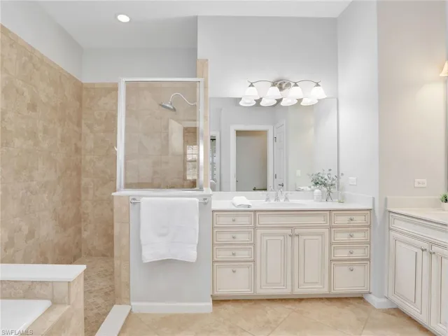 Bathroom with vanity, tile patterned flooring, walk in shower, and a bath