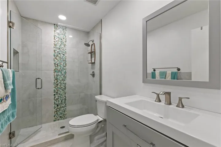 Full bath featuring vanity, a stall shower, and recessed lighting