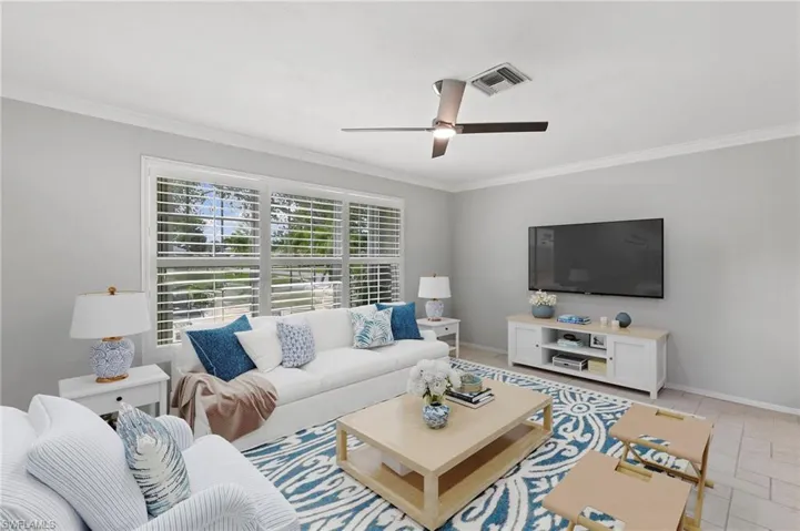 Living area featuring crown molding and a ceiling fan