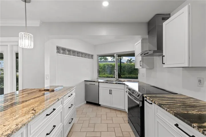 Kitchen with black electric range, white cabinetry, dark stone countertops, and recessed lighting