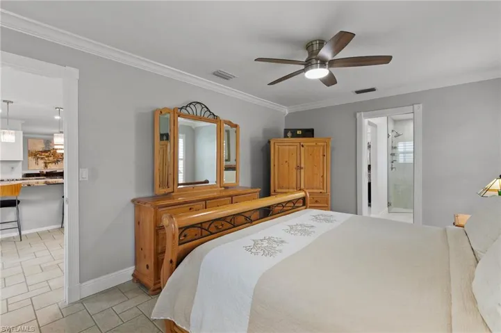 Bedroom featuring crown molding, a ceiling fan, and ensuite bathroom