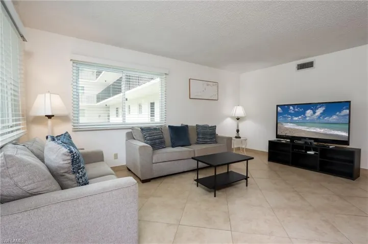 Living area with a textured ceiling and light tile patterned floors