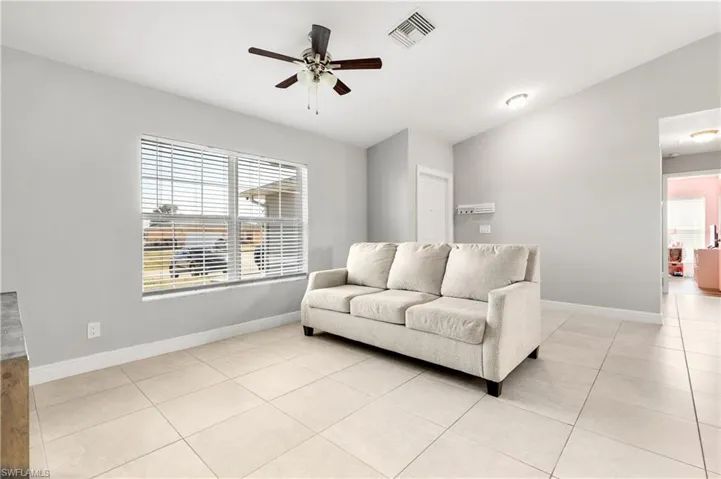 Tiled living room featuring ceiling fan