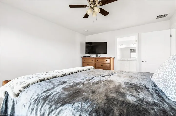 Bedroom featuring connected bathroom and ceiling fan