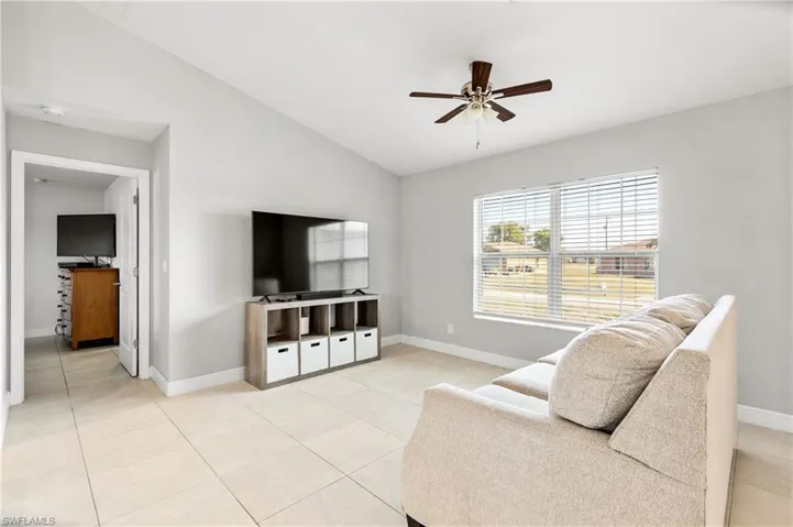 Sitting room featuring vaulted ceiling, ceiling fan, and light tile patterned flooring