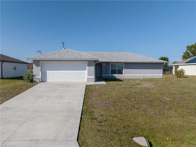 Single story home featuring a garage and a front yard