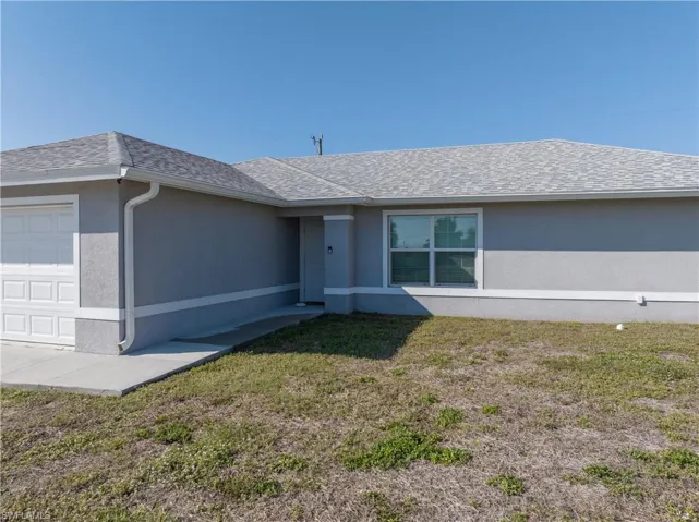 Ranch-style house with a front lawn and a garage