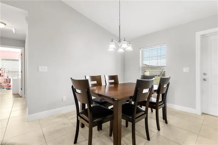 Dining space with light tile patterned floors and a chandelier