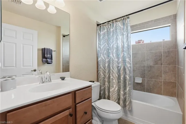 Full bathroom featuring shower / bathtub combination with curtain and vanity
