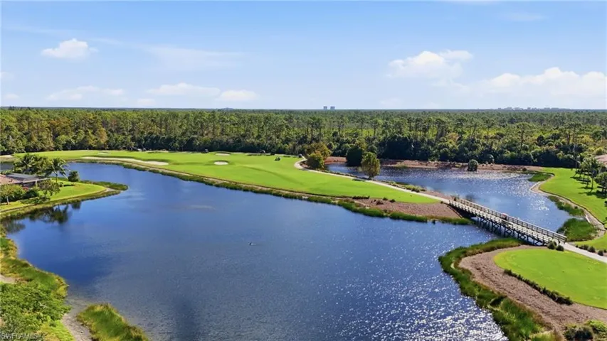 Water view featuring a heavily wooded area and a golf club
