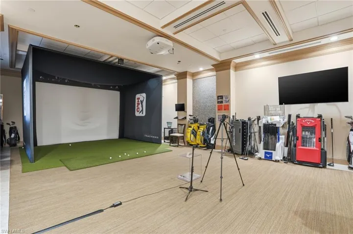 Game room with golf simulator and ornamental molding