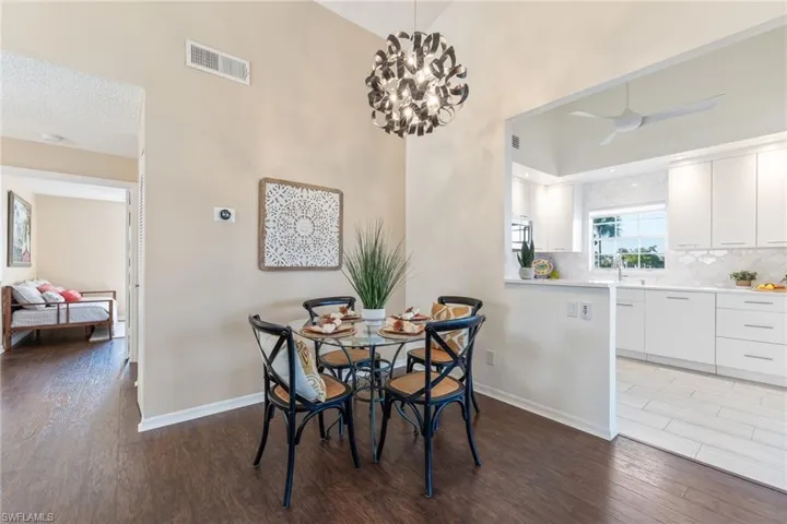 Dining room featuring ceiling fan with notable chandelier, sink, hardwood / wood-style floors, and a textured ceiling