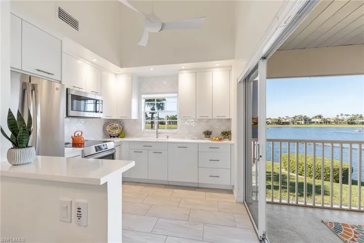 Kitchen with sink, stainless steel appliances, a water view, white cabinets, and kitchen peninsula