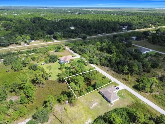 Aerial view of property and surrounding area featuring a heavily wooded area and property boundaries highlighted