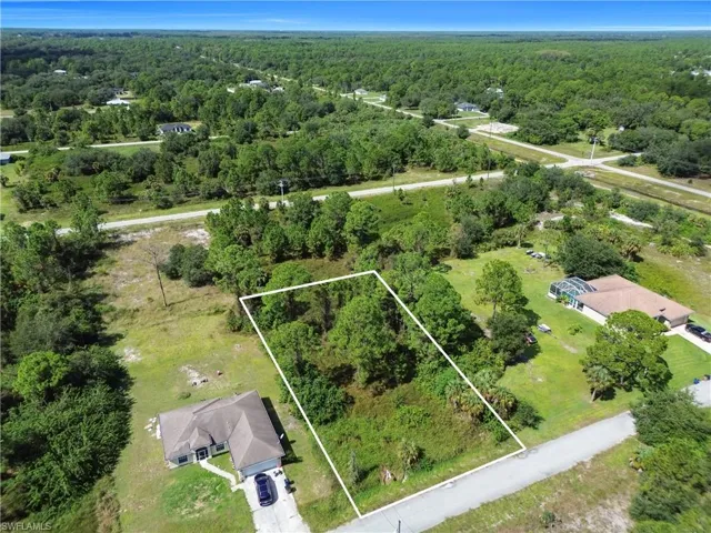 Aerial overview of property's location with a heavily wooded area and property parcel outlined