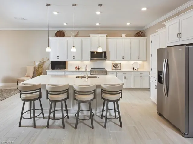 The well-equipped kitchen features stainless steel appliances, plenty of cabinet space, and a large kitchen island perfect for food prep and casual dining.