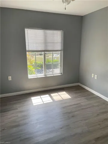 Unfurnished room featuring dark hardwood / wood-style floors and ceiling fan