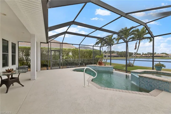 View of newly surfaced swimming pool featuring a patio area, a pool with connected hot tub, a lanai, and a lavish water view