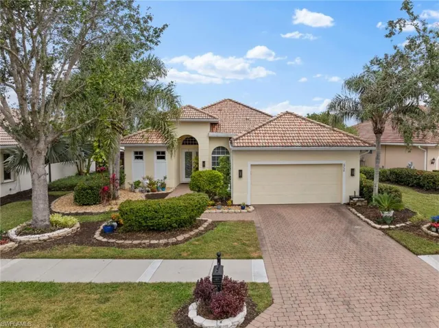 Mediterranean / spanish-style house featuring stucco siding, a tile roof, decorative driveway, a front yard, and a 2 car garage