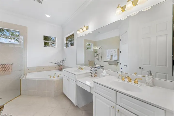 Master bath with a double sink, a garden tub, a walk in shower, and tile flooring