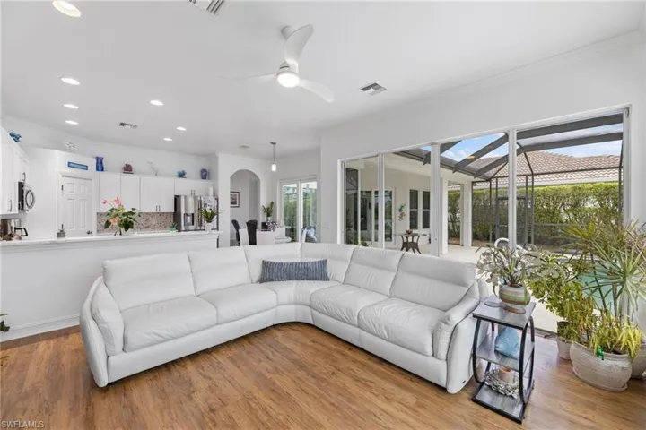 Living room with wood look ceramic tile floors, a ceiling fan, and ornamental molding