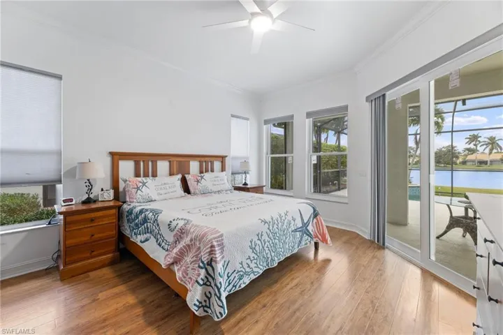 Bedroom with sliding glass sliding door to outside, multiple windows overlooking, and wood-type flooring