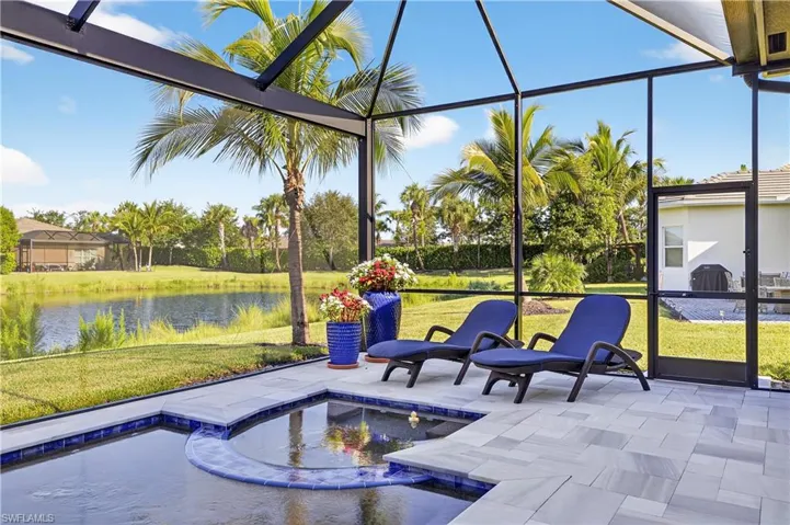 Swimming pool with a jacuzzi, glass enclosure, a yard, and a sunroom