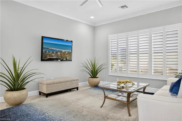Living room featuring ornamental molding, wood finished floors, recessed lighting, and ceiling fan