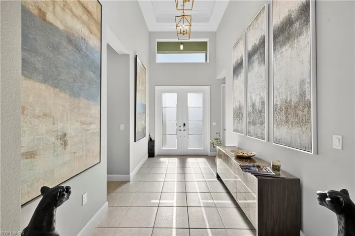 Entrance foyer with french doors, light tile patterned floors, and a high ceiling