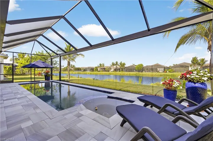 Swimming pool with a yard, a water view, glass enclosure, and a sunroom