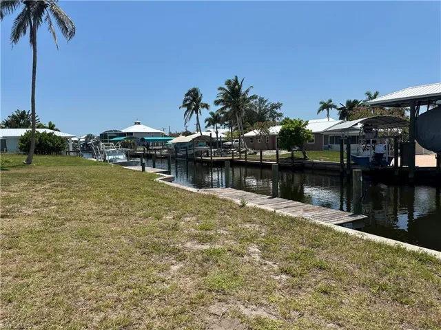 Dock area with a water view and a yard
