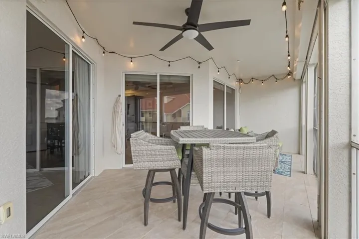 Sunroom with ceiling fan, a patio area, and outdoor dining area