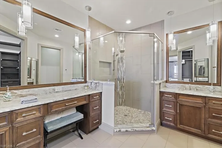 Bathroom featuring a shower stall, vanity, light tile patterned floors, a spacious closet, and recessed lighting