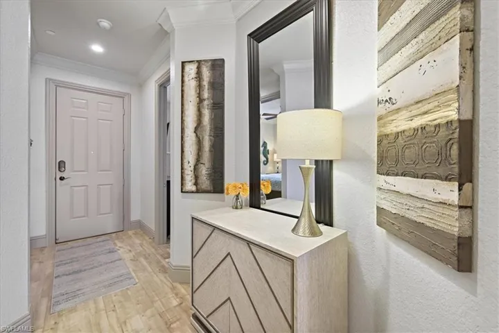 Foyer entrance featuring ornamental molding and light wood-style floors