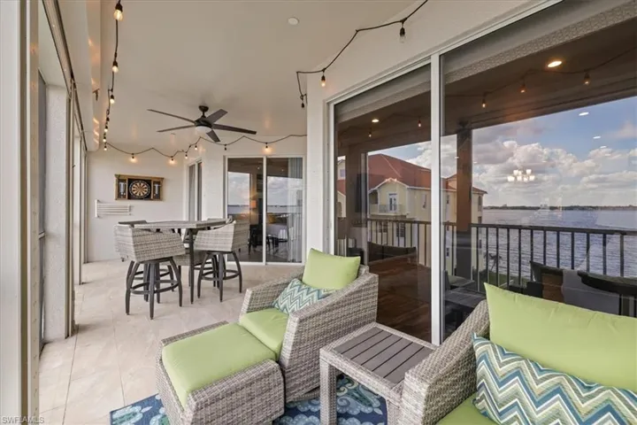 Sunroom / solarium with an outdoor living space, a ceiling fan, and a water view