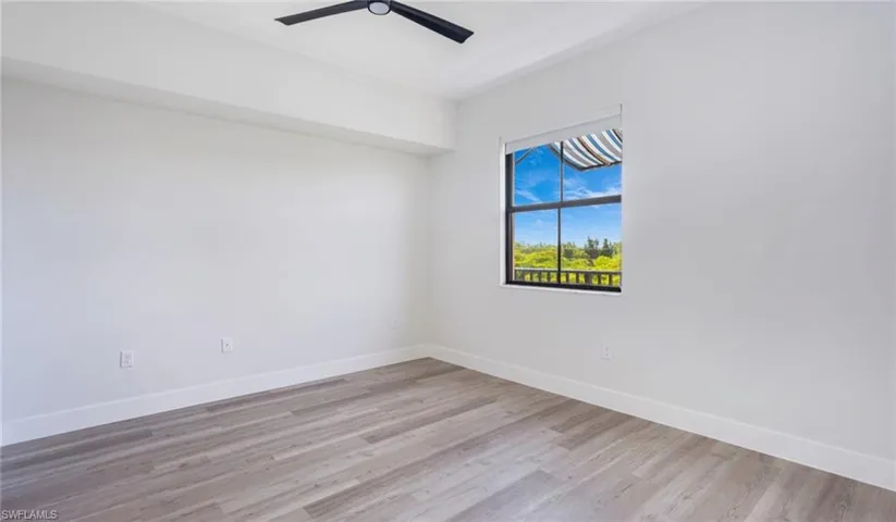 Unfurnished room featuring light wood finished floors, ceiling fan, and baseboards