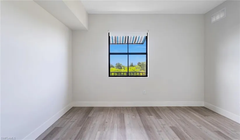 Empty room featuring visible vents, baseboards, and light wood-style flooring