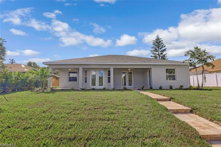 Single story home with french doors, stucco siding, and covered porch