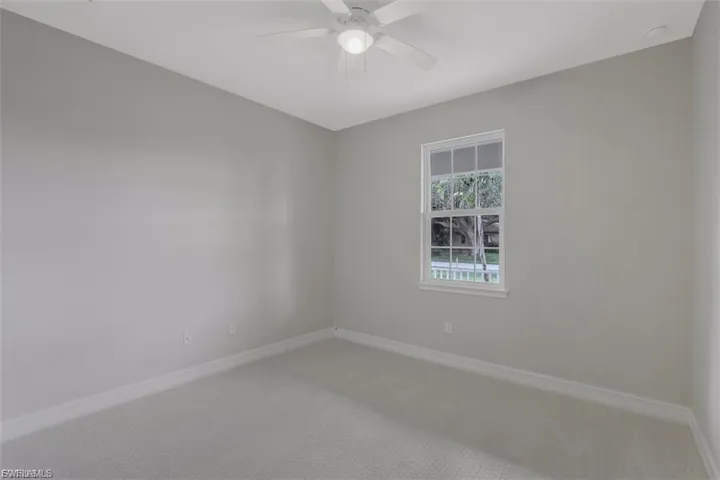 Spare room featuring carpet and ceiling fan