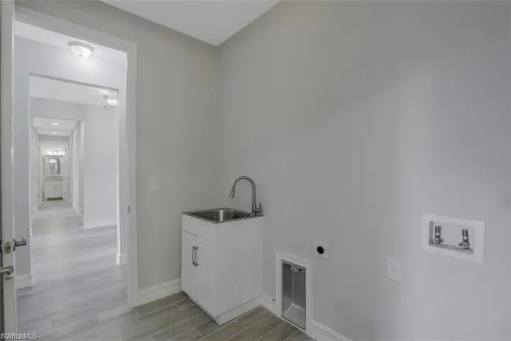 Laundry area with washer hookup, wood finish floors, and hookup for an electric dryer