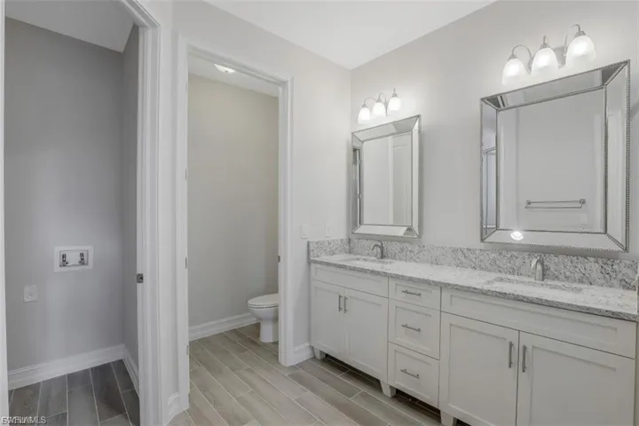 Bathroom featuring double vanity and wood tiled floors