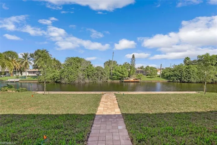 View of grassy yard with a water view